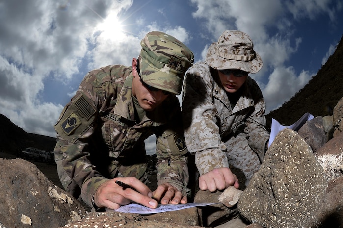U.S. Army Cpl. Gregory McLellan and U.S. Marine Corps Cpl. Clinton Smith plot grid points during a joint training exercise at Arta, Djibouti. Through informal methods like training exercises, as well as formally established joint forums, the services  work together to share new technology and ideas to develop, test and deliver ever-better capabilities for Marines and Soldiers.  (U.S. Air Force photo by Tech. Sgt. Dan DeCook)