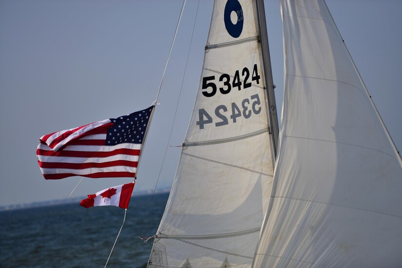 An American flag flies with a Canadian flag aboard a sailboat during the Tri-Services Regatta on the Chesapeake Bay, Va., Sept. 11, 2016. The Tri-Services Regatta is held by different military-affiliated yacht clubs each year, this year the race was held to support the 15th anniversary of 9/11.  (U.S. Air Force photo by Airman 1st Class Tristan Biese)