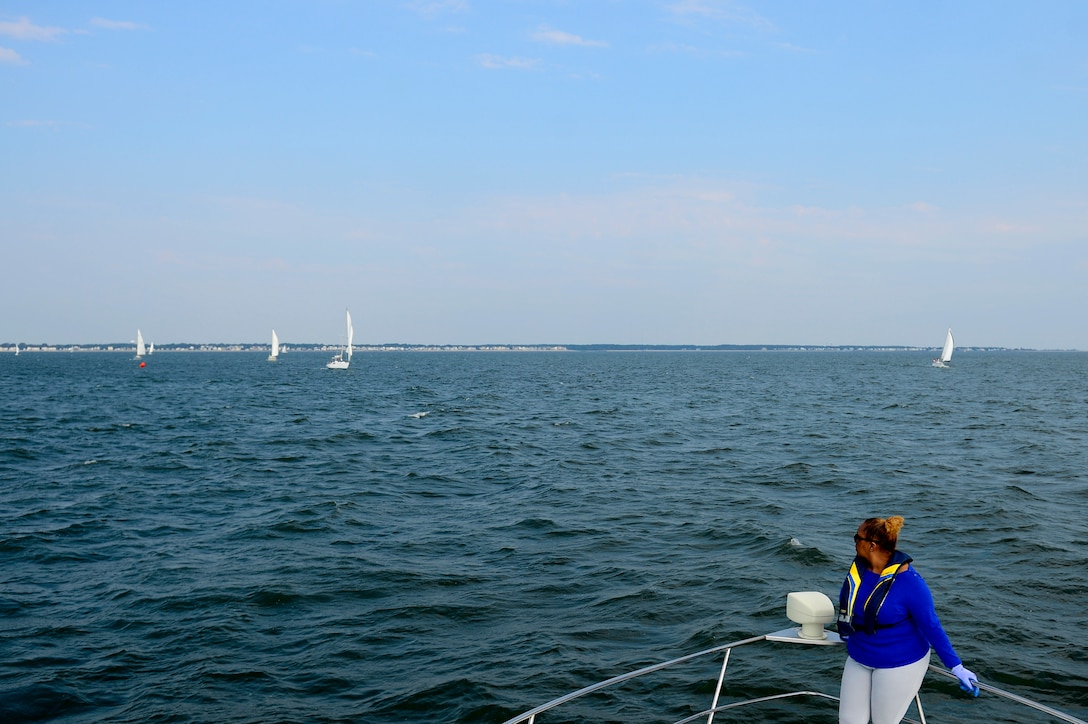 Retired U.S. Air Force Master Sgt. Debra Wesley, Langley Yacht Club race committee score keeper and boatswain mate, watches sailboats while waiting to drop the anchor of the committee boat during the Tri-Services Regatta on Chesapeake Bay, Va., Sept. 11, 2016. The annual race between the U.S Air Force, U.S. Army, U.S. Navy and military-orientated sailing clubs was in remembrance of the 15th anniversary of 9/11. (U.S. Air Force photo by Airman 1st Class Kaylee Dubois)