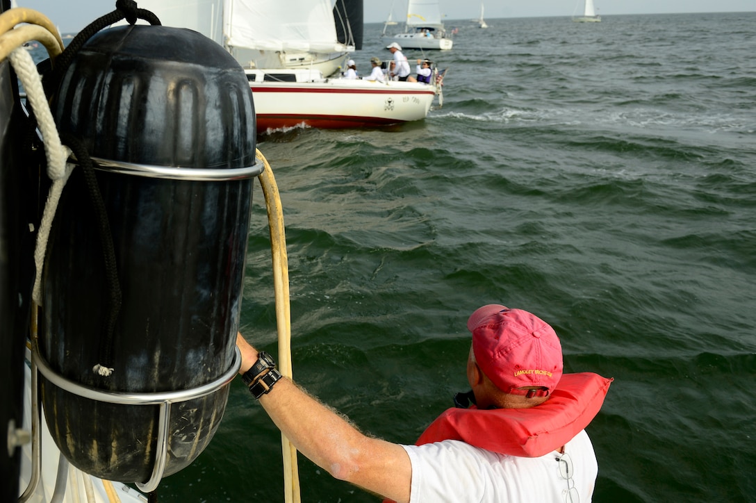 Retired U.S. Air Force Capt. Gary Herbert, Langley Yacht Club race captain and line judge, welcomes sailboat crews participating in the Tri-Services Regatta on Chesapeake Bay, Va., Sept. 11, 2016. The race encouraged camaraderie and friendly-competition between the U.S. Air Force, U.S. Army, U.S. Navy and military-affiliated yacht clubs. (U.S. Air Force photo by Airman 1st Class Kaylee Dubois) 