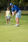 Mike Calloway, honorary commander, sinks a putt as his wife and teammate Sandy Calloway looks on at the 2016 fall Bluesuiters Golf Tournament Sept. 9, 2016, at the Eagle Creek Golf Course on Dover Air Force Base, Del. The biannual tournament also features raffles, door prizes and a lunch at the clubhouse. (U.S. Air Force photo by Mauricio Campino)