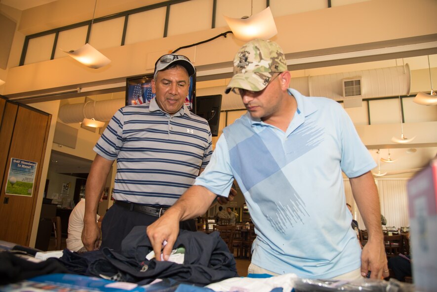 Two participants of the 2016 fall Bluesuiters Golf Tournament receive their door prizes Sept. 9, 2016, at the Eagle Creek Golf Course on Dover Air Force Base, Del. The biannual tournaments offer Team Dover Airmen a chance to win various prizes and connect with local civic and business leaders. (U.S. Air Force photo by Mauricio Campino)