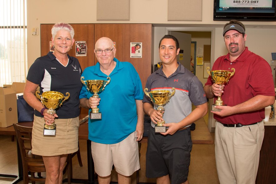 Dawne Nickerson-Banez, 436th Public Affairs community relations chief, presents trophies to first place winners Bill Hare, Capt. Christian Drescher, 436th Airlift Wing flight safety officer, and Corey Sheldon at the 2016 fall Bluesuiters Golf Tournament on Sept. 9, 2016, at the Eagle Creek Golf Course on Dover Air Force Base, Del. Bluesuiters is a biannual golf tournament aimed at connecting Team Dover Airmen with local civic and business leaders. (U.S. Air Force photo by Mauricio Campino)