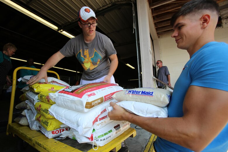 Petty Officer 2nd Class Corey Loewe, left, and Lance Cpl. Stuart Dunlap stack bags of rice to be given to people in need during the U.S. Department of Agriculture’s annual Feds Feed Families food drive at Religious Community Services in New Bern, N.C., Sept. 7, 2016. Launched in 2009 as part of President Barack Obama’s United We Serve campaign, the nationwide drive has collected over 52 million pounds of nonperishable food items for people struggling to put food on their table. MCAS Cherry Point personnel were responsible for donating 26,805 pounds of nonperishable food items. Loewe is the leading petty officer for the station chapel with Headquarters and Headquarters Squadron and Dunlap is a refrigeration and air conditioning technician with Marine Wing Communications Squadron 28, Marine Air Control Group 28, 2nd Marine Aircraft Wing. U.S. Marine Corps photo by Cpl. Jason Jimenez/Released)