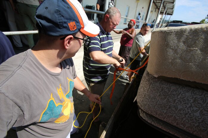 Petty Officer 2nd Class Corey Loewe, left, Lt. Cmdr. Paul Greer, center and Seaman Apprentice Austin Stepson help load mattresses during the U.S. Department of Agriculture’s annual Feds Feed Families food drive at Religious Community Services in New Bern, N.C., Sept. 7, 2016. Launched in 2009 as part of President Barack Obama’s United We Serve campaign, the nationwide drive has collected over 52 million pounds of nonperishable food items for people struggling to put food on their table. MCAS Cherry Point personnel were responsible for donating 26,805 pounds of nonperishable food items. Loewe is the leading petty officer and Stepson is a boatswains mate, both with Headquarters and Headquarters Squadron and Greer is the chaplain for Marine Aircraft Control Group 28, 2nd Marine Aircraft Wing. (U.S. Marine Corps photo by Cpl. Jason Jimenez/Released)