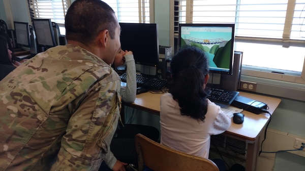 Capt. Park led the bridge design workshop using computer generated simulation. Middle school students were challenged to build a working bridge using the most cost effective means available.