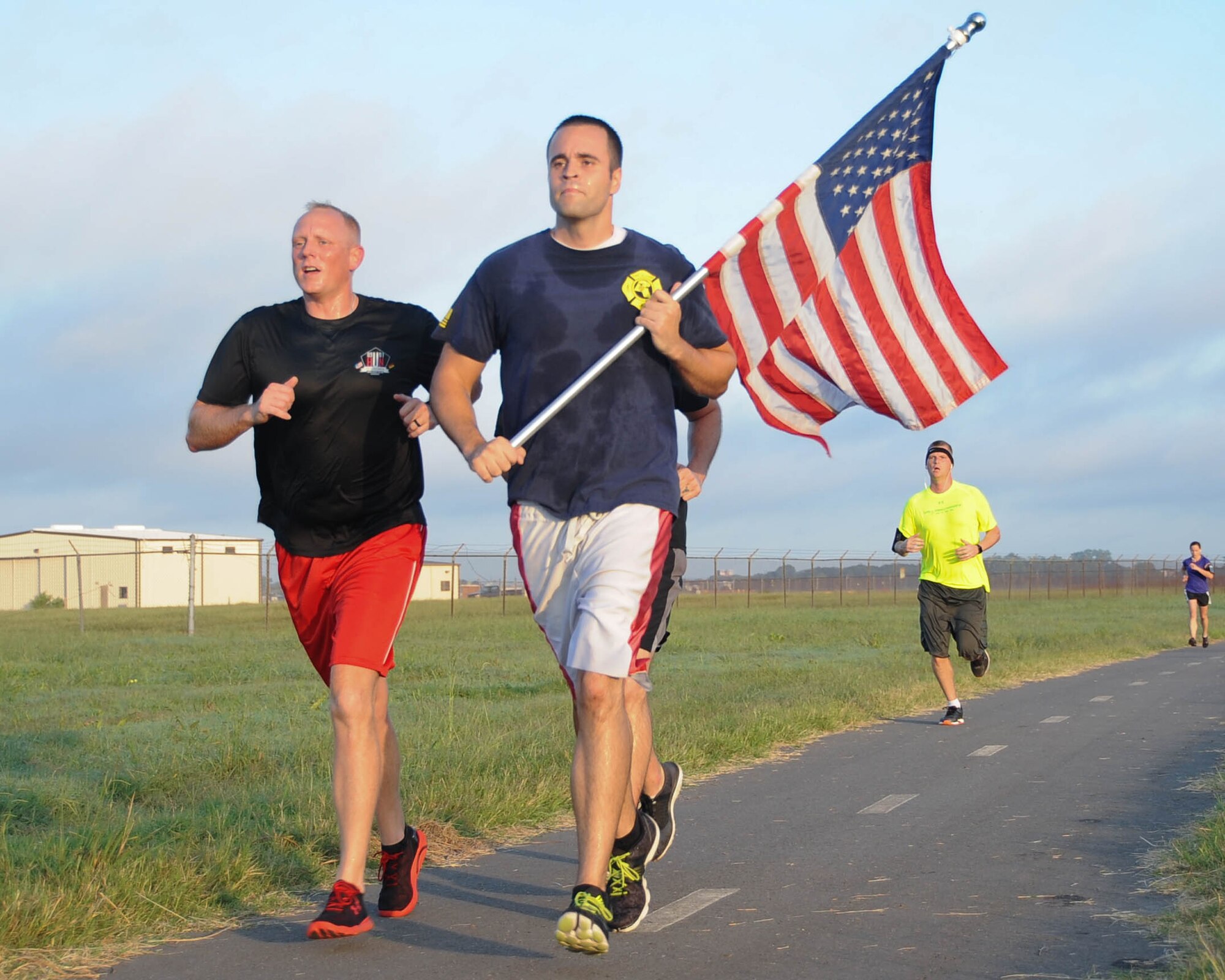 A participant of the 9/11 5K run carries the American flag as he approaches the finish line at Barksdale Air Force Base, La., Sept. 9, 2016. The run was in remembrance of the Sept. 11, 2001 terrorist attacks. (U.S. Air Force photo/Airman 1st Class Stuart Bright) 