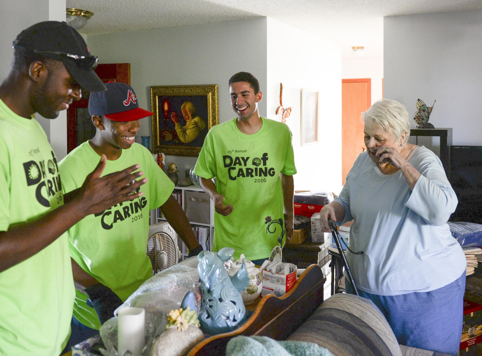 Airmen 1st Class Brandon, Michael and Shawndell, Day of Caring volunteers, who are heating, ventilation and air conditioning technicians with the 49th Civil Engineer Squadron here, laugh with Donna, a disabled resident, in Alamogordo, N.M. on Sept. 9, 2016. The Airmen helped to beautify Donna’s front lawn and backyard, and also helped her to move some furniture. (Last names are being withheld due to operational requirements. U.S. Air Force photo by Airman Alexis P. Docherty)