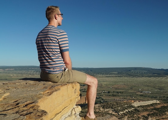 Senior Airman Troy Serad, an engineering assistant with the 446th Civil Engineer Squadron, sits near the edge of a cliff after hiking to Pyramid Rock June 14, 2016, near Gallup, N.M. During Serad’s 10th grade year of high school he was homeless and dropped out of school. Serad eventually went back to school and is currently studying for the entrance exam to law school. (U.S. Air Force Reserve photo by Tech. Sgt. Bryan Hull)