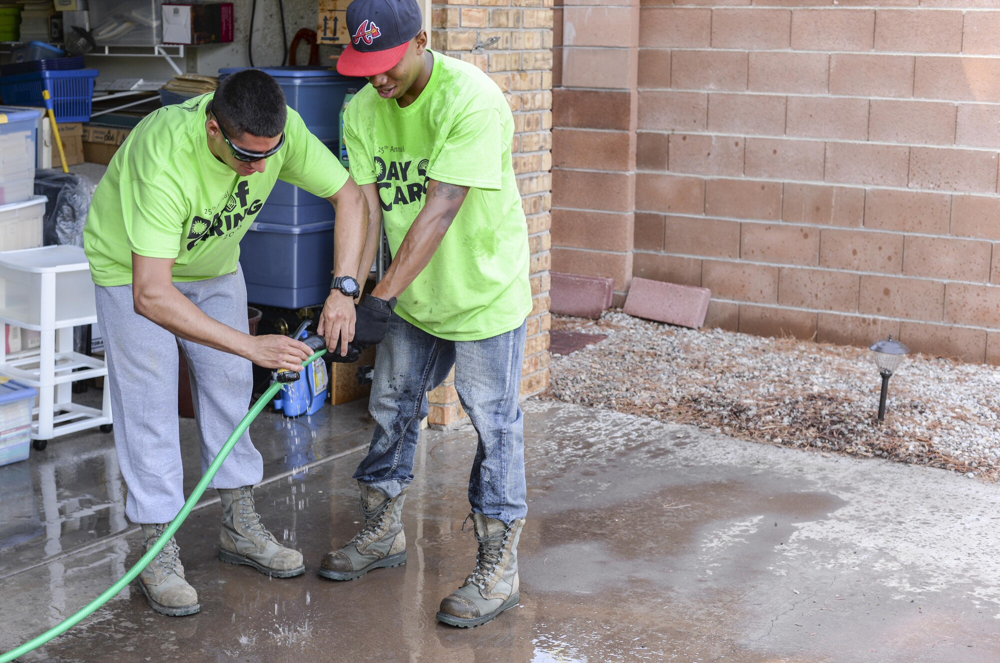 Airmen 1st Class Michael and Shawndell, Day of Caring volunteers, who are both heating, ventilation and air conditioning technicians with the 49th Civil Engineer Squadron here, fix a disabled resident’s faulty watering hose in Alamogordo, N.M. on Sept. 9, 2016. Hundreds of Holloman Airmen volunteered for the 25th annual Day of Caring. (Last names are being withheld due to operational requirements. U.S. Air Force photo by Airman Alexis P. Docherty)