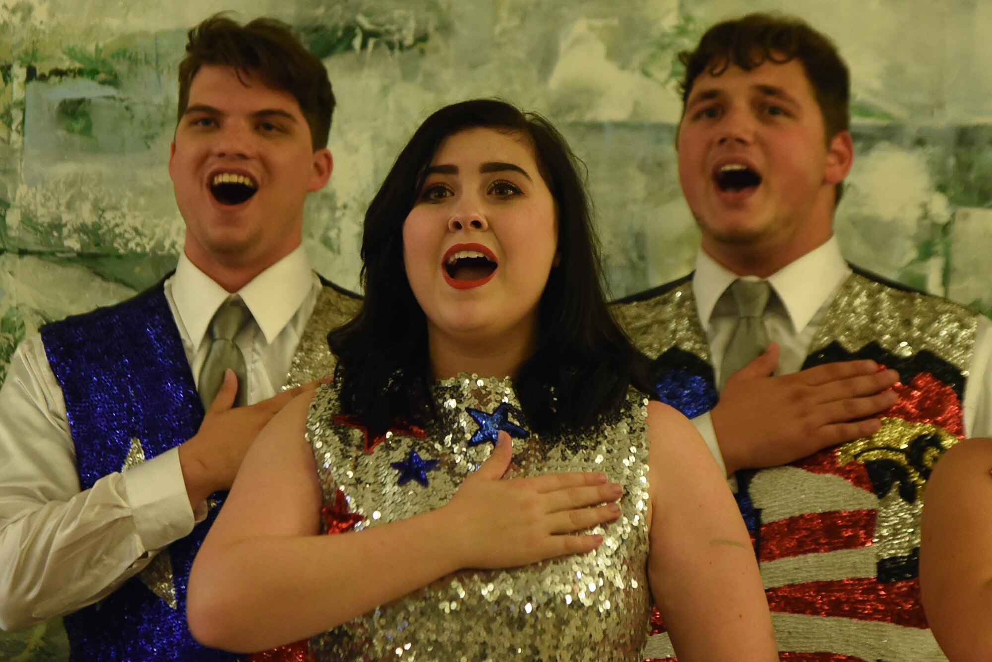 Hannah Swanson, Austin Keretzman and Jonathan Hepler, Re-Creation USA performers, sing a patriotic song while they hold their hands to their hearts during a performance at the Alaska Fisher House at Joint Base Elmendorf-Richardson, Alaska, Sept. 9, 2016. The next day’s performance took the group to the state veteran’s home in Palmer.