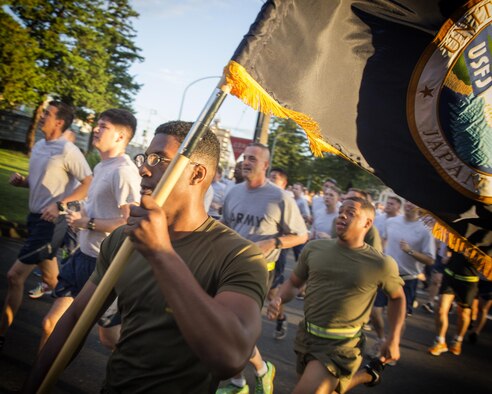 Marine Sgt. Terrez Walker, US Forces, Japan administrative NCO of logistics and installations, holds an old USFJ colors during the USFJ Command 5K Run at Yokota Air Base, Japan, Sept. 9, 2016. At the end of the run Maj. Gen. Charles Chiarotti and other USFJ leadership retired the old USFJ colors and uncased the new command colors. (U.S. Air Force photo by Yasuo Osakabe/Released) 