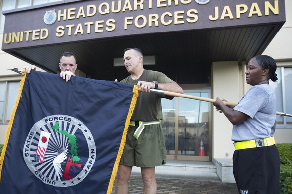 Marine Maj. Gen. Charles Chiarotti, US Forces, Japan commander, and Army Col. Cory Mendenhall, USFJ chief of staff, unfurl the new USFJ command flag at Yokota Air Base, Japan, Sept. 9, 2016, after the USFJ Command 5K Run. The new USFJ logo includes several elements that symbolize the enduring partnership between the U.S. and Japan. The national flags of both the U.S. and Japan are placed side-by-side near the top of the design. The U.S. flag represents over 106,000 service members, government employees, contractors, and family members who serve in Japan. The Japanese flag represents all of Japan, both the people of Japan and the Self-Defense Forces. The Torii gate and Mount Fuji are widely recognized as iconic symbols of Japanese culture. (U.S. Air force photo by Yasuo Osakabe/Released) 
