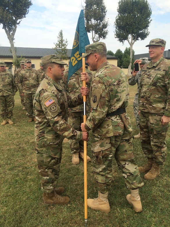 Brig. Gen. Steven W. Ainsworth, center, the commanding general of the 7th Mission Support Command, passes the 2500th Digital Liaison Detachment guideon to incoming commander Col. Christopher Varhola, left, during the unit's change of command ceremony Sunday, September 11, 2016 at Hoekstra Field, on Caserma Ederle in Vicenza, Italy. Varhola took command of the unit from Col. David Mundfrom, right.
