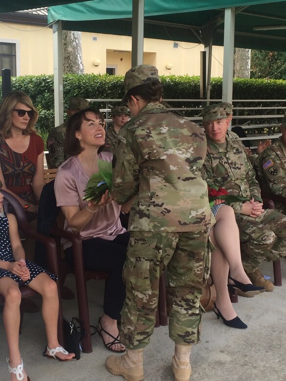 Laura Varhola is presented with a bouquet of yellow flowers to welcome her into the 2500th Digital Liasion Detachment during a ceremony Sunday, September 11, 2016 at Hoekstra Field, on Caserma Ederle in Vicenza, Italy. Her husband,  Col. Christopher Varhola, took command of the 2500th Digital Liaison Detachment from Col. David Mundfrom. Brig. Gen. Steven W. Ainsworth, the commanding general of the 7th Mission Support Command, presided over the ceremony, passing the unit's guideon from the outgoing to the incoming commander. (Photos by 1st Lt. Julie McCabe)