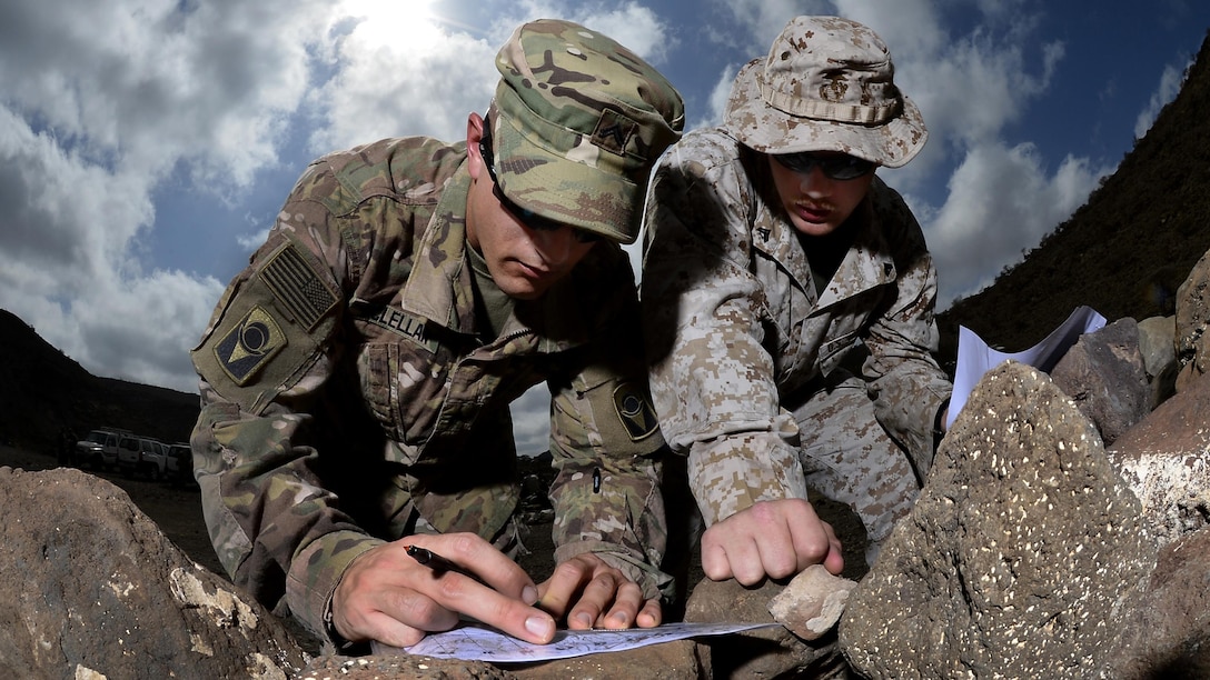 U.S. Army Cpl. Gregory McLellan and U.S. Marine Corps Cpl. Clinton Smith, Joint Corporals Leadership Development Course students, plot grid points during the land navigation portion of Camp Lemonnier's Joint Corporal’s Leadership Development Course at Arta, Djibouti, March 3, 2016. During the evaluation ‎Soldiers, ‎Sailors, ‎Airmen, and ‎Marines had to find eight different points and navigate to those points in a timed event.