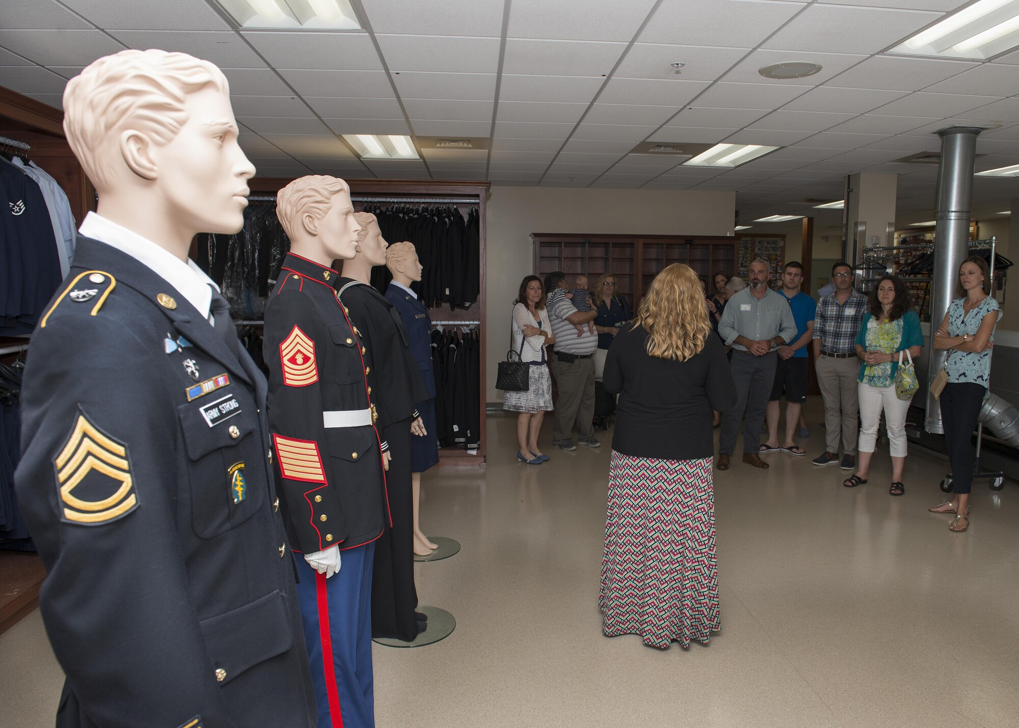 Christin Michaud, Air Force Mortuary Affairs Operations Public Affairs, gives a group of Team Dover spouses a tour of AFMAO’s uniform room during a spouses’ tour Sept. 7, 2016, on Dover Air Force Base, Del. AFMAO's mission and privilege is to fulfill the nation's sacred commitment of ensuring dignity, honor and respect to the fallen and care, service and support to their families. (U.S. Air Force photo by Senior Airman Zachary Cacicia)