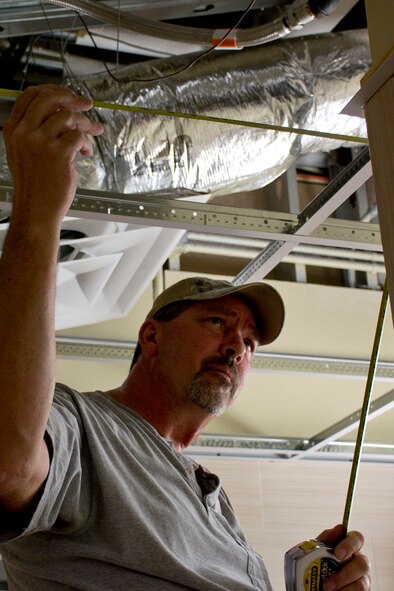 Ken Shumate, a carpenter with HGL Construction, Midwest City, Okla., installs metal ceiling grids in a bathroom of building #1995 at Little Rock Air Force Base, Ark., Sept. 1, 2016. The building is currently being remodeled for use as administrative and training offices. (U.S. Air Force photo by Master. Sgt. Jeff Walston/Released)        