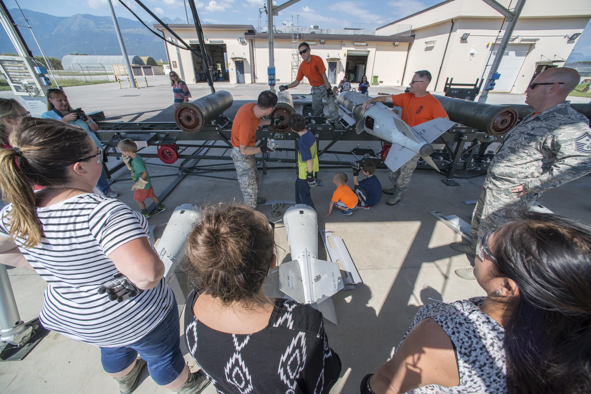 Spouses and children of the 31st Munitions Squadron gather to build mock munitions during a family open house event at Aviano Air Base, Italy on Sept. 9, 2016. The family members learned about munition equipment and received a tour of the squadron facilities. (U.S. Air Force photo by Airman 1st Class Cory W. Bush/Released)