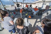 Spouses and children of the 31st Munitions Squadron gather to build mock munitions during a family open house event at Aviano Air Base, Italy on Sept. 9, 2016. The family members learned about munition equipment and received a tour of the squadron facilities. (U.S. Air Force photo by Airman 1st Class Cory W. Bush/Released)