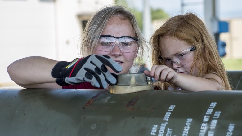 Carolyn Hampton and her daughter, Abigail, build mock munitions during a dependents event at Aviano Air Base, Italy on Sept. 9, 2016. Spouses and children of 31st Munitions Squadron Airmen spent the day touring squadron facilities and participating in on-the-job activities to understand what their Airmen do on a daily basis. (U.S. Air Force photo by Airman 1st Class Cory W. Bush/Released)