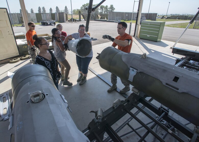 Spouses and children of 31st Munitions Squadron Airmen build mock munitions during a family open house event at Aviano Air Base, Italy on Sept. 9, 2016. The family members learned about munition equipment and toured squadron facilities. (U.S. Air Force photo by Airman 1st Class Cory W. Bush/Released)
