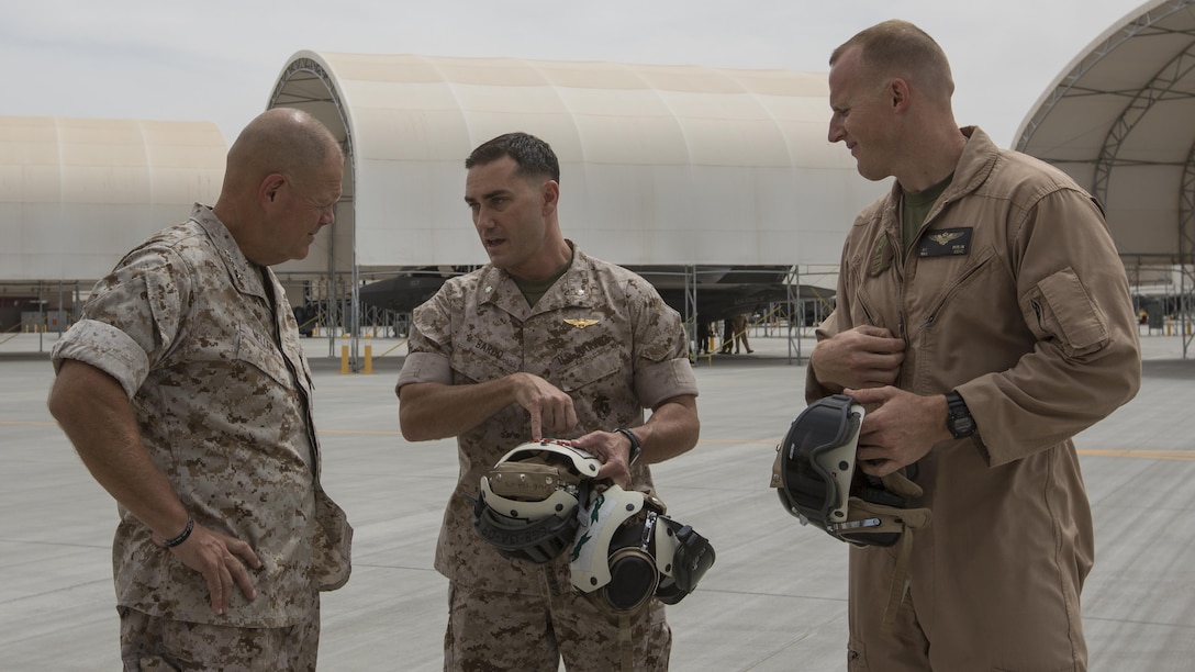 Commandant of the Marine Corps Gen. Robert B. Neller, left, listens to Lt. Col. Tyler Bardo, commanding officer of Marine Fighter Attack Squadron 121, center, during a tour at Marine Corps Air Station Yuma, Ariz., Sept. 13, 2016. Neller visited Yuma to meet with Marines and tour facilities.