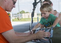 Maj. Joseph Pulliam, 31st Munitions Squadron commander, and Riley Gould, son of Staff Sgt. Derek Gould, 31st MUNS munitions inspector, build a mock munition during a family open house event at Aviano Air Base, Italy on Sept. 9, 2016. Spouses and children of 31st MUNS Airmen spent the day touring squadron facilities and participating in on-the-job activities to better understand what their Airmen do on a daily basis. (U.S. Air Force photo by Airman 1st Class Cory W. Bush/Released)