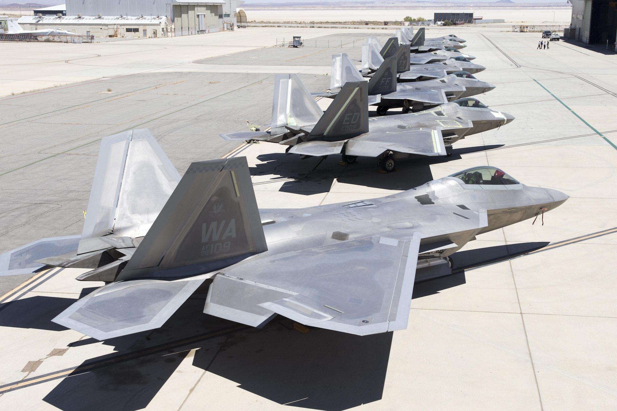 Seven F-22A Raptors sit outside the 411th Flight Test Squadron Aug. 10. Four operational jets from three different bases are at Edwards for testing to help improve the long-term combat capability of the F-22 Raptor. (U.S. Air Force photo by Christian Turner)