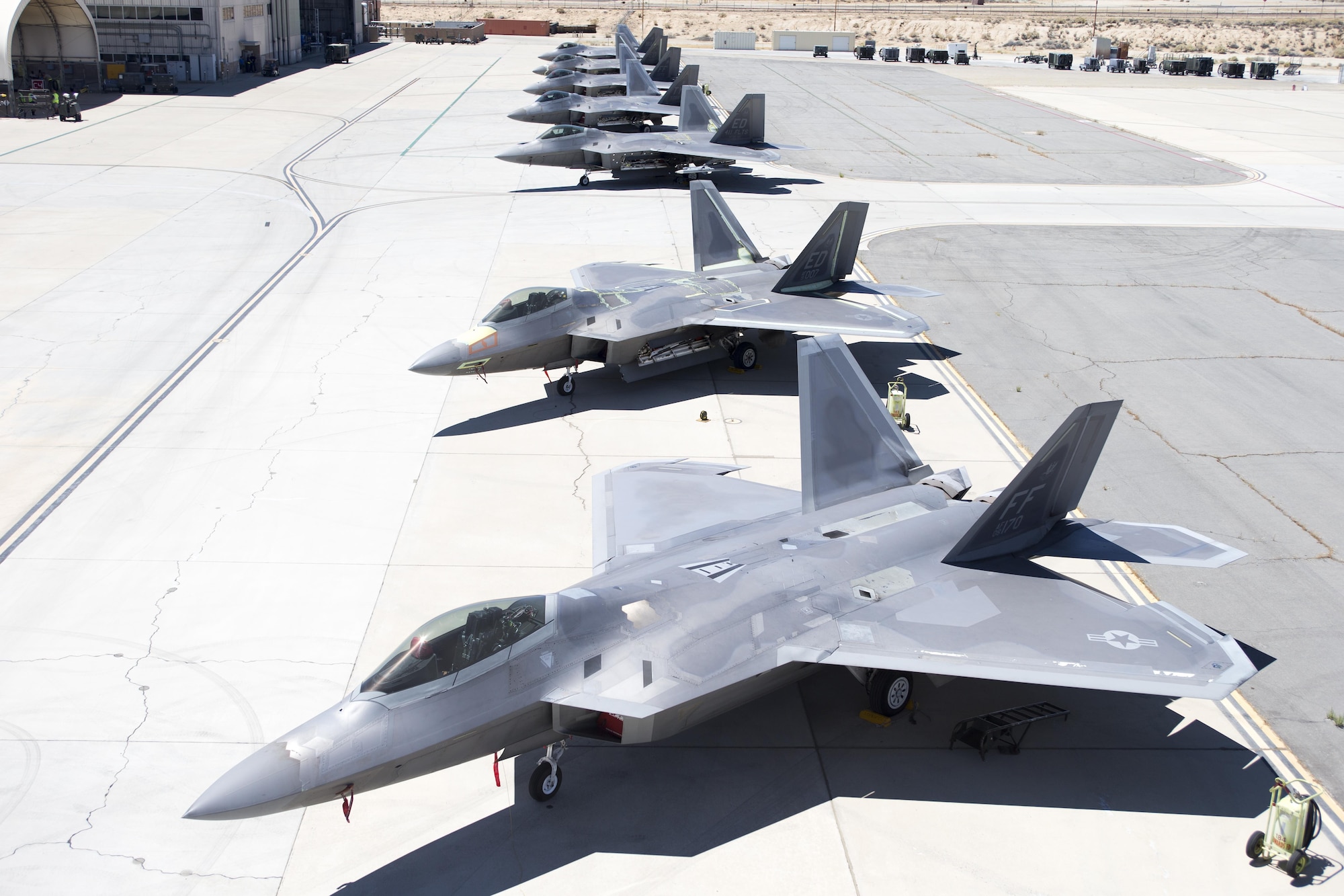 Seven F-22A Raptors sit outside the 411th Flight Test Squadron Aug. 10. Four operational jets from three different bases are at Edwards for testing to help improve the long-term combat capability of the F-22 Raptor. (U.S. Air Force photo by Christian Turner)