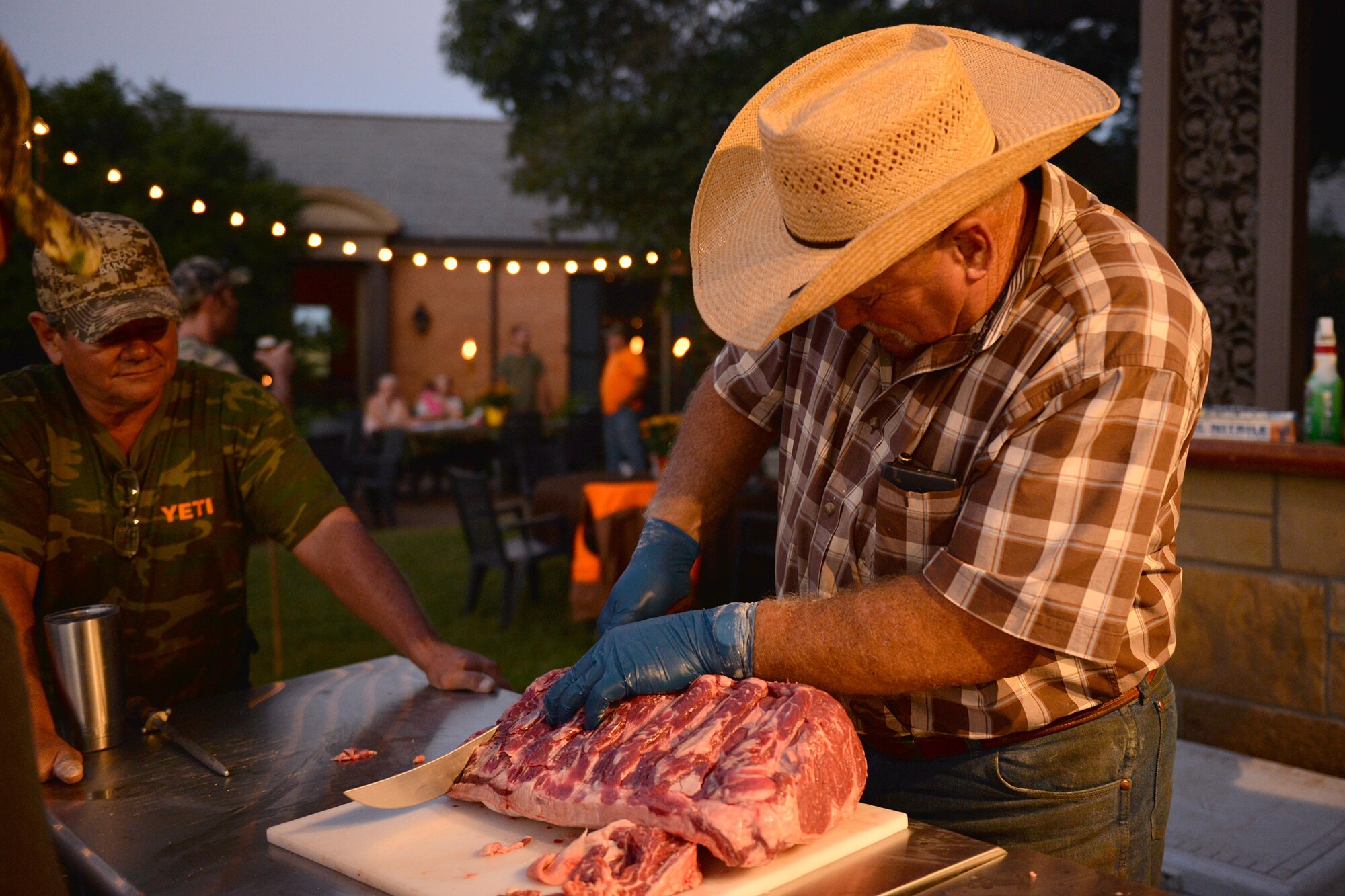 Jeff Fitts slices pieces of steak for Airmen from Sheppard Air Force Base, Texas, who participated in the 12th Annual Clay County Dove Salute in Henrietta, Texas, Sept. 10, 2016. Nearly 175 Airmen were invited to the Birdwell and Clark Ranch to hunt dove. After the hunt, each Airman was given a hand-cut steak to grill and offered many other home-cooked foods to enjoy. (U.S. Air Force photo by Senior Airman Kyle E. Gese)