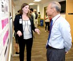 Allison Tempel (left) discusses her research with Kai Leung, Ph.D., during the summer intern poster presentation at the U.S. Army Institute of Surgical Research at Fort Sam Houston Aug. 10.