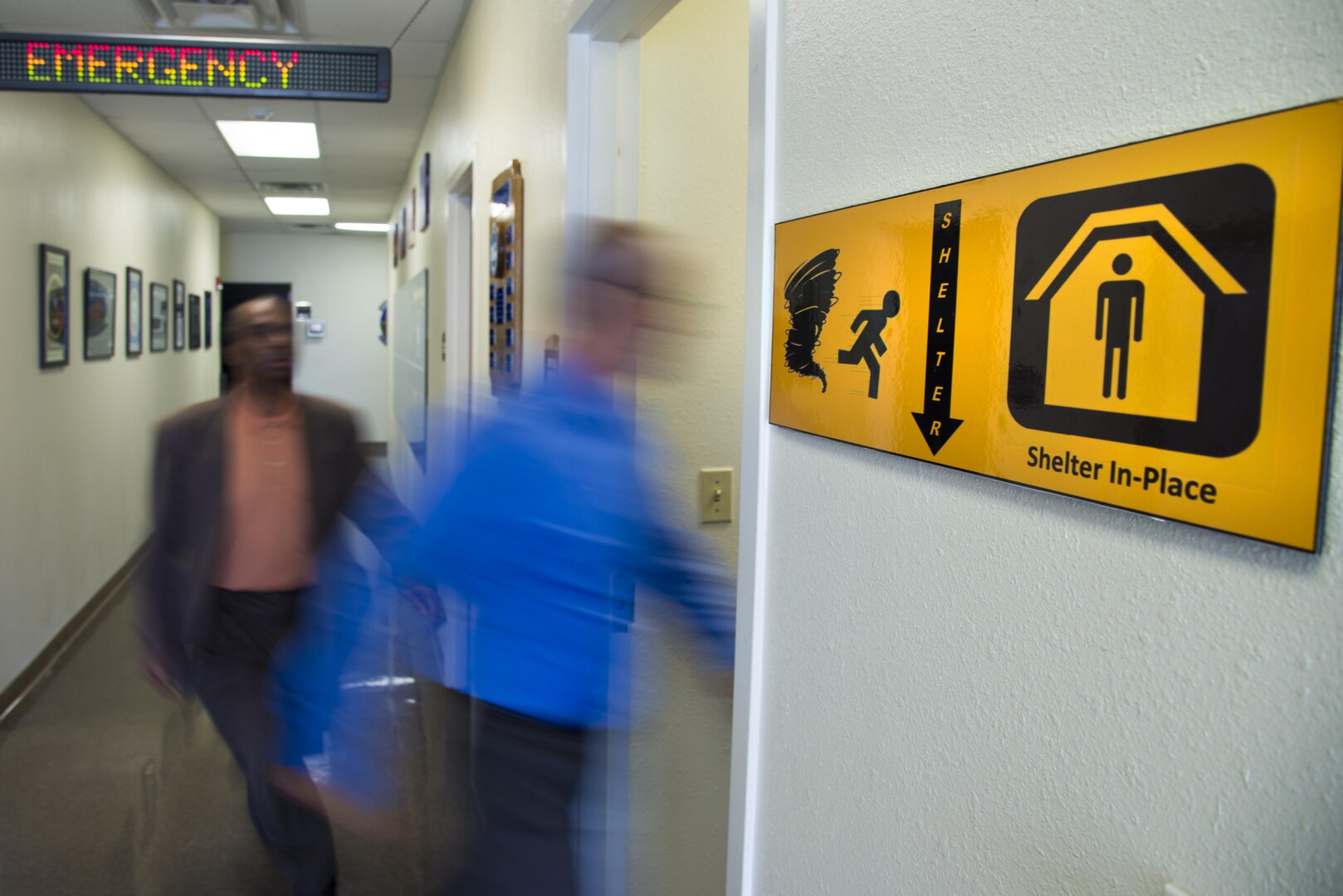 Members of the 502nd Civil Engineering Squadron, Emergency Management Flight enter their office shelter in-place location during a simulated emergency Sep. 7, 2016. September is National Preparedness Month which gives the opportunity to remind Department of Defense personnel and their families to be prepared at all times to respond quickly to disasters and emergencies.  