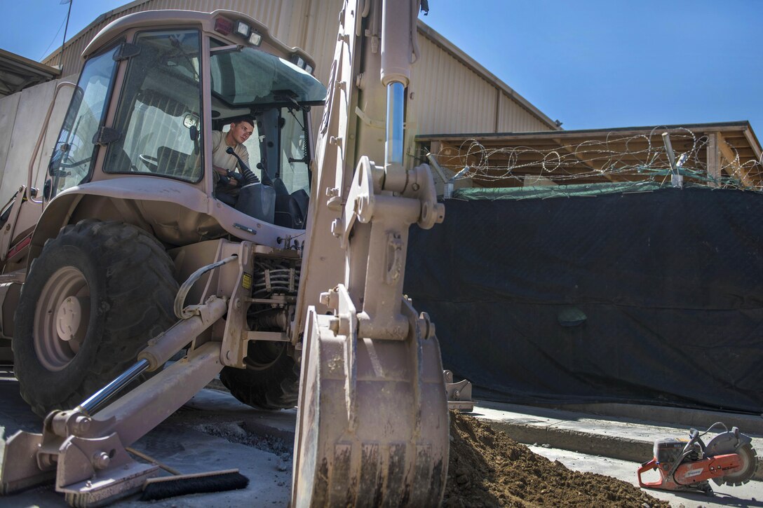Senior Airman Jacob Nevills, a pavements and equipment technician, operates a backhoe to remove dirt from a ditch at Bagram Airfield, Afghanistan, Sept. 7, 2016. Nevills is assigned to the 455th Expeditionary Civil Engineer Squadron. The squadron's engineers, known as “Dirt Boys”, worked to construct a new drainage system at the passenger terminal. Air Force photo by Senior Airman Justyn M. Freeman