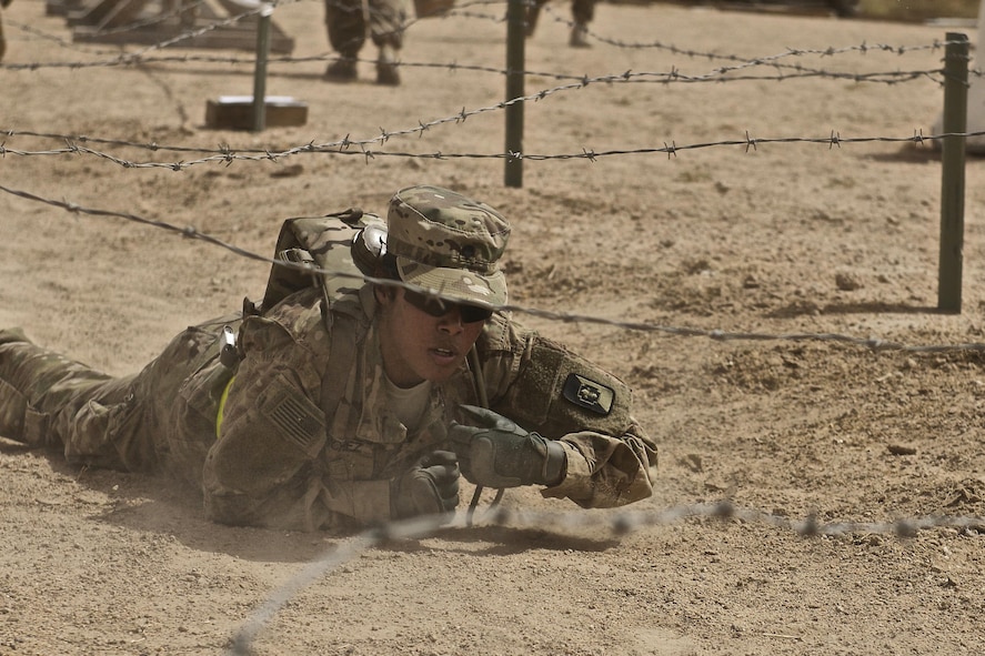 Army Spc. Dayanna Sanchez, a native of Havana, high-crawls under an obstacle.