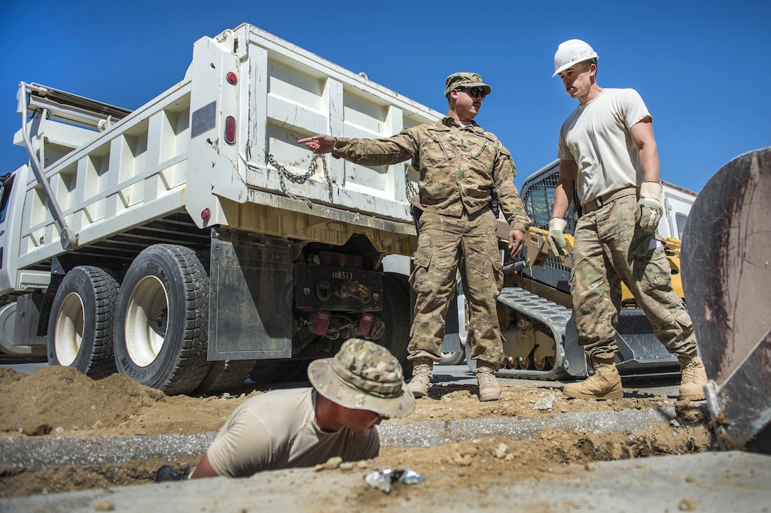 Pavement and equipment technicians dig a hole at a construction site at Bagram Airfield, Afghanistan, Sept. 7, 2016. The technicians are assigned to the 455th Expeditionary Civil Engineer Squadron. The site was prepared for a new drainage system designed to collect excess water and precipitation. Air Force photo by Senior Airman Justyn M. Freeman