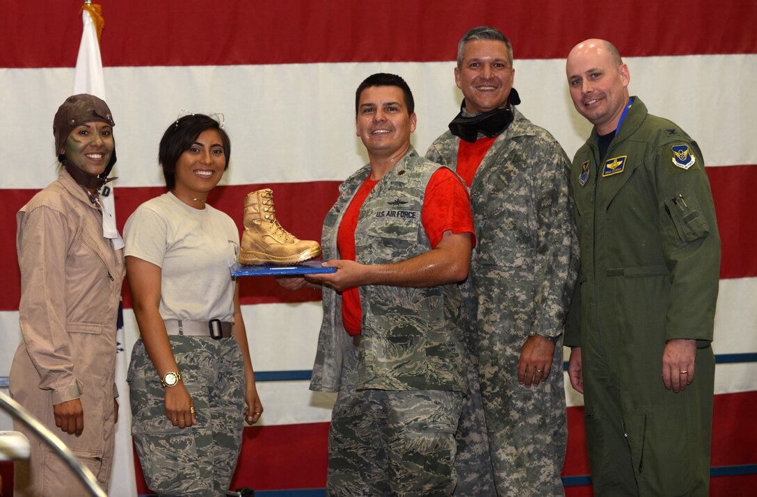 Maj. Eric Ashe, commander of the 28th Communications Squadron, and Chief Master Sgt. William Catts, superintendent of the 28th CS, receive a Golden Boot for best squadron table decorations at Ellsworth Air Force Base, S.D., Sept. 9, 2016. During the dining out, Airmen were authorized alternative uniform wear and encouraged to decorate their units table in an effort to win a “Spirit Award.”(U.S. Air Force photo by Airman 1st Class Donald C. Knechtel)