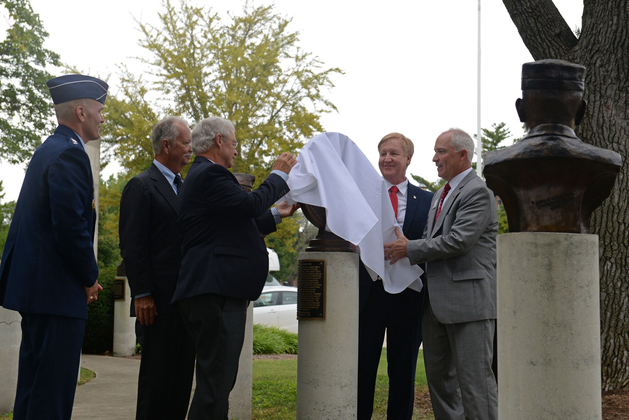 Three of six honorees, called “Pathfinder Loadmasters,” unveil a bronze medallion commemorating their accomplishments in revolutionizing C-17A operations, at Scott Air Force Base, Illinois, Sept. 8, 2016. Gen. Carlton D. Everhart II, Commander, Air Mobility Command and Retired Chief Master Sgt. Mike Kerver, President of the Airlift/Tanker Association, were also there to help honor these individuals. They are listed on the plaque in Mobility Memorial Park: Chief Master Sgt. William (Bill) M. Cannon, deceased, Chief Master Sgt. Marion (Dave) D. Fincher, Chief Master Sgt. (Mike) M. Welch, Chief Master Sgt. James (Jim) Lis, Chief Master Sgt. Mark A. Smith, and Master Sgt. Theodore (Ted) R. Venturini. (U.S. Air Force photo by Senior Airman Erica Fowler)