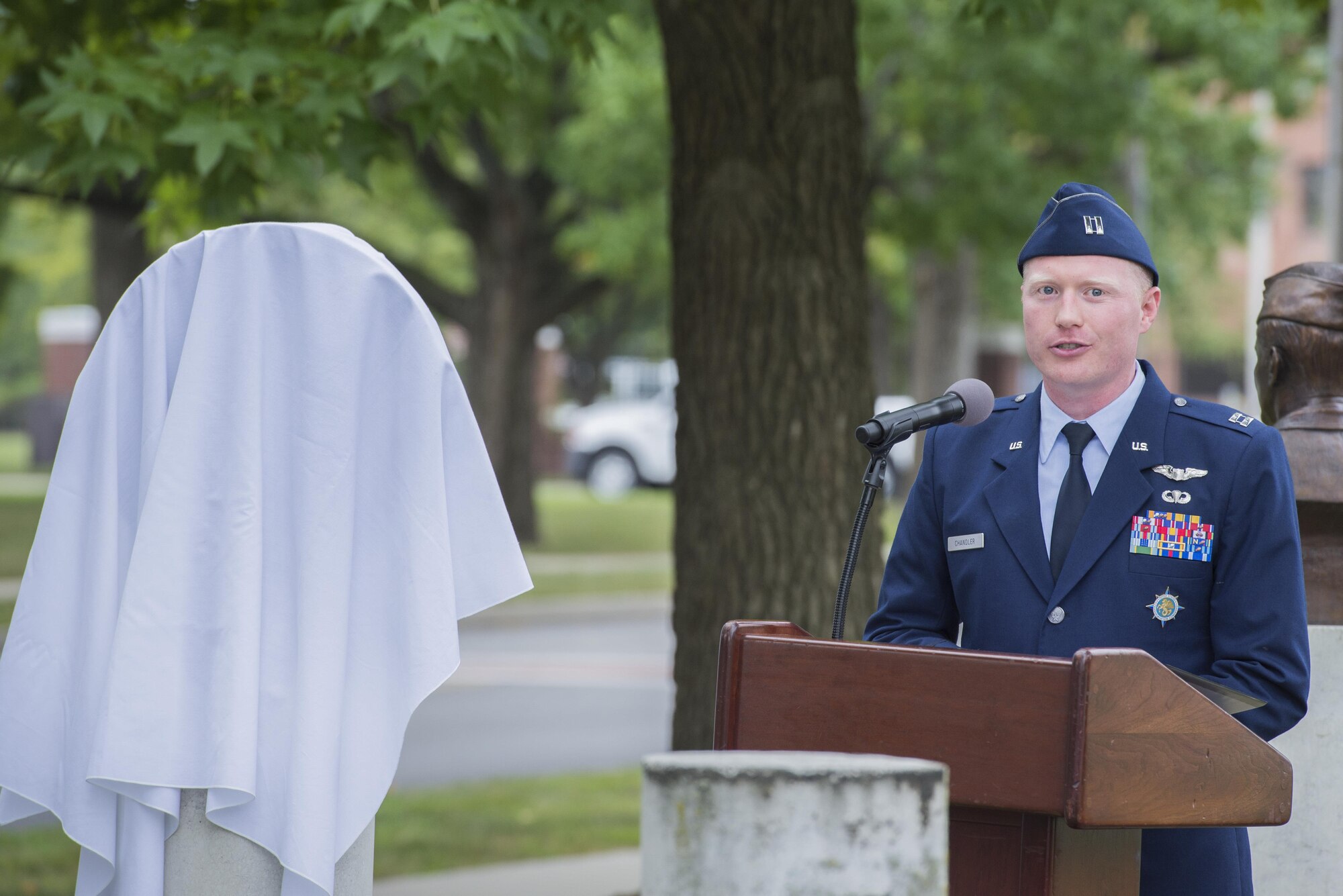Capt. Steven Chandler, president of Scott Air Force Base Huyser Chapter of the Airlift/Tanker Association speaks as the master of ceremonies during a bust dedication at Scott AFB Sept. 8, 2016. The bronze bust was dedicated to the C-17A Pathfinder loadmasters for their efforts in providing the leadership and expertise necessary to guide Mcdonnell Douglas and Military Airlift Command to produce the C-17 Globemaster III. (U.S. Force Photo by Airman Daniel Garcia)