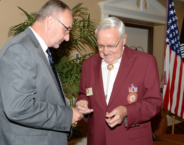 Kent Morrison, executive director, Marine Corps Logistics Base Albany, presents a coin to retired Army Col. Quin Herlik, former Prisoner of War and guest of honor for the POW/MIA Recognition Breakfast, Sept. 9.