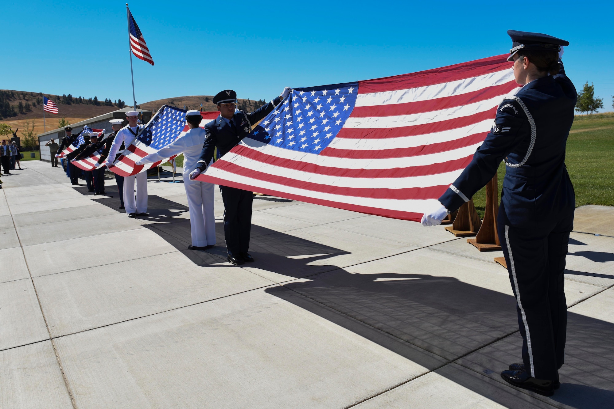 Fairchild Air Force Base honor guard presents the American Flag alongside the Air Force's sister services during the Missing in America Interment Service Sept. 13, 2016, at Washington State Cemetery at Medical Lake, Washington. More than 60 veterans were interred during the ceremony. (U.S. Air Force photo/Senior Airman Nick J. Daniello)