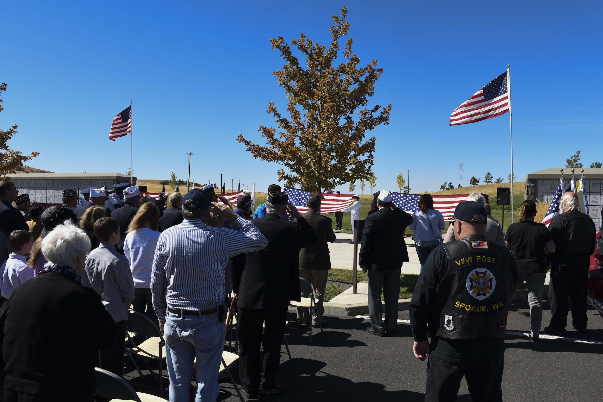 Attendees salute during the presentation of the American Flag during the Missing in America Interment Service Sept. 13, 2016, at Washington State Cemetery at Medical Lake, Washington. Over 100 people attended the ceremony to witness the veterans interred. (U.S. Air Force photo/Senior Airman Nick J. Daniello)