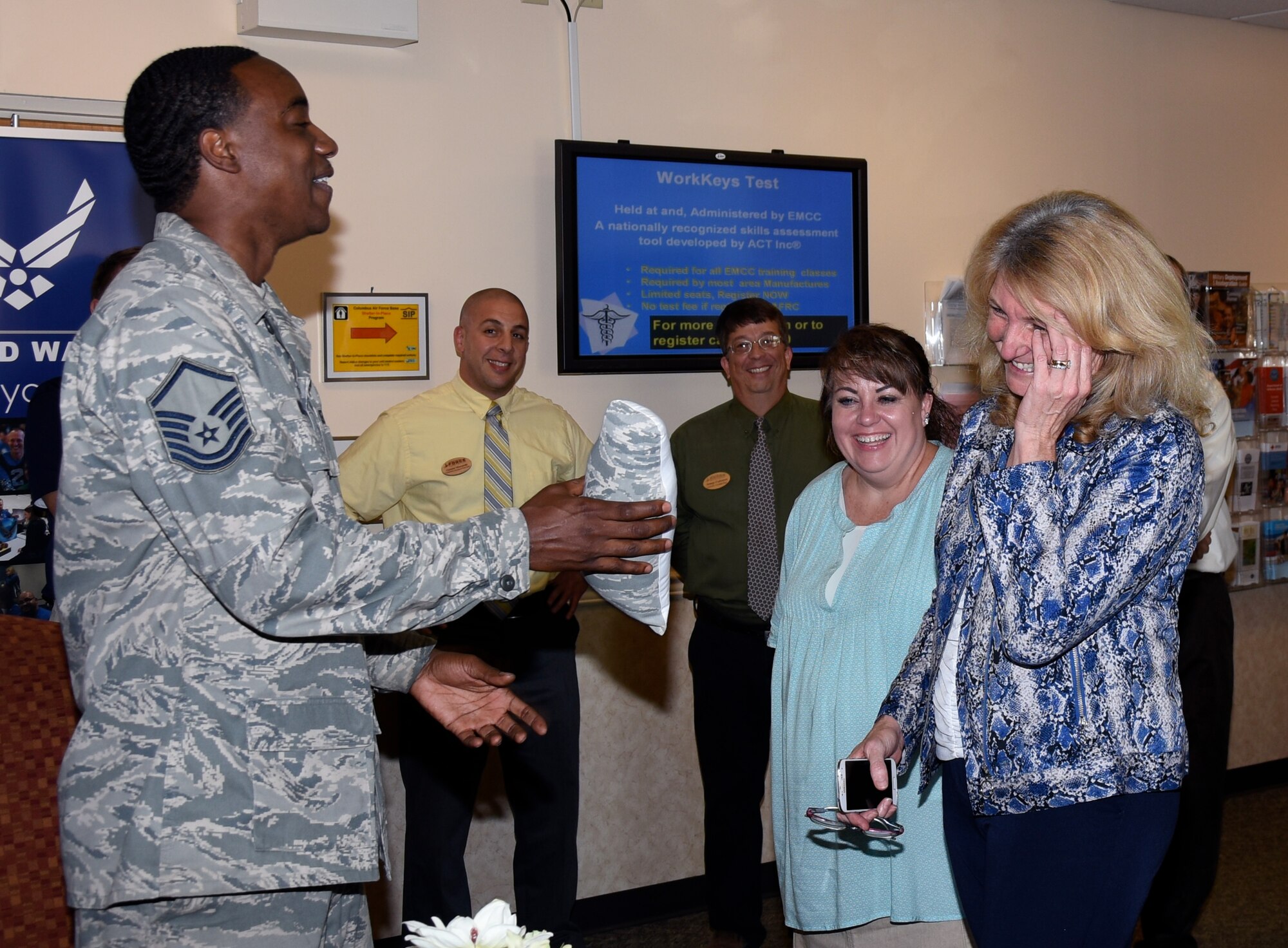 Master Sgt. Rodney McInnis, Airman and Family Readiness Center readiness noncommissioned officer, hands Cheryl Roberson a huggable uniform gift Sept. 12, 2016, at Columbus Air Force Base, Mississippi. HUGs are made for families of deployed members.  The keepsake includes the deployed member’s image and plays a personalized message from the deployed member. (U.S. Air Force photo by Sharon Ybarra)