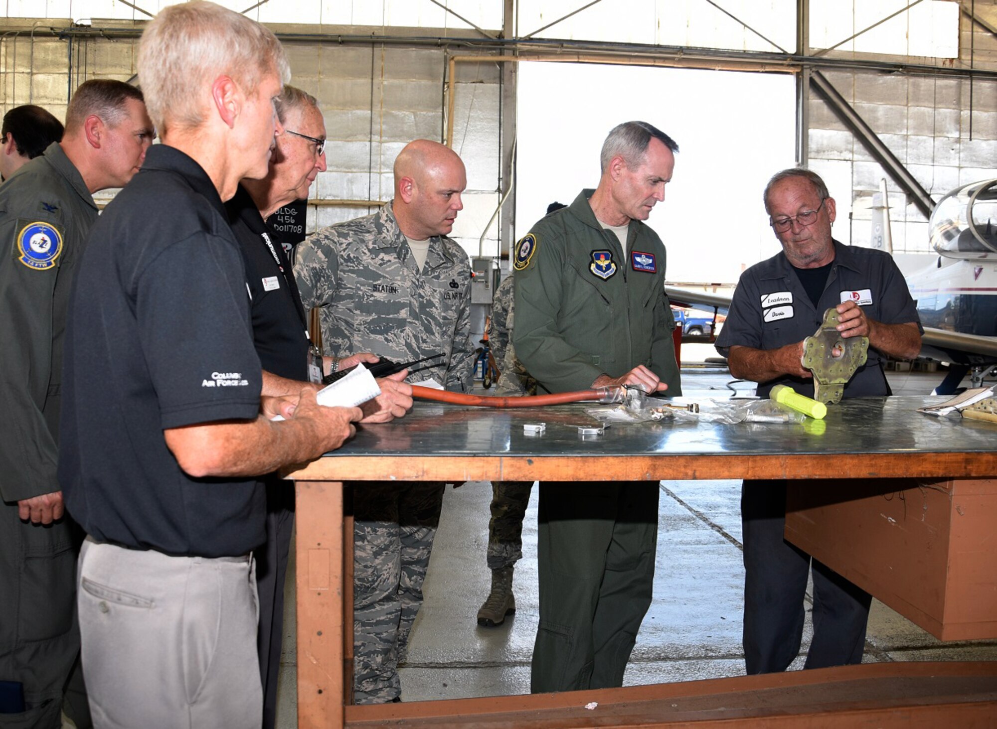Jeff Davis, L3 Vertex Aerospace T-6 lead mechanic, briefs Lt. Gen. Darryl Roberson, commander of Air Education and Training Command, Chief Master Sgt. David Staton, AETC command chief, and base leaders, about T-6 landing gear trunnion fittings Sept. 12, 2016, at Columbus Air Force Base, Mississippi. Roberson had the opportunity to get an extensive look at what makes the T-6 an aerial asset for AETC. (U.S. Air Force photo by Elizabeth Owens)