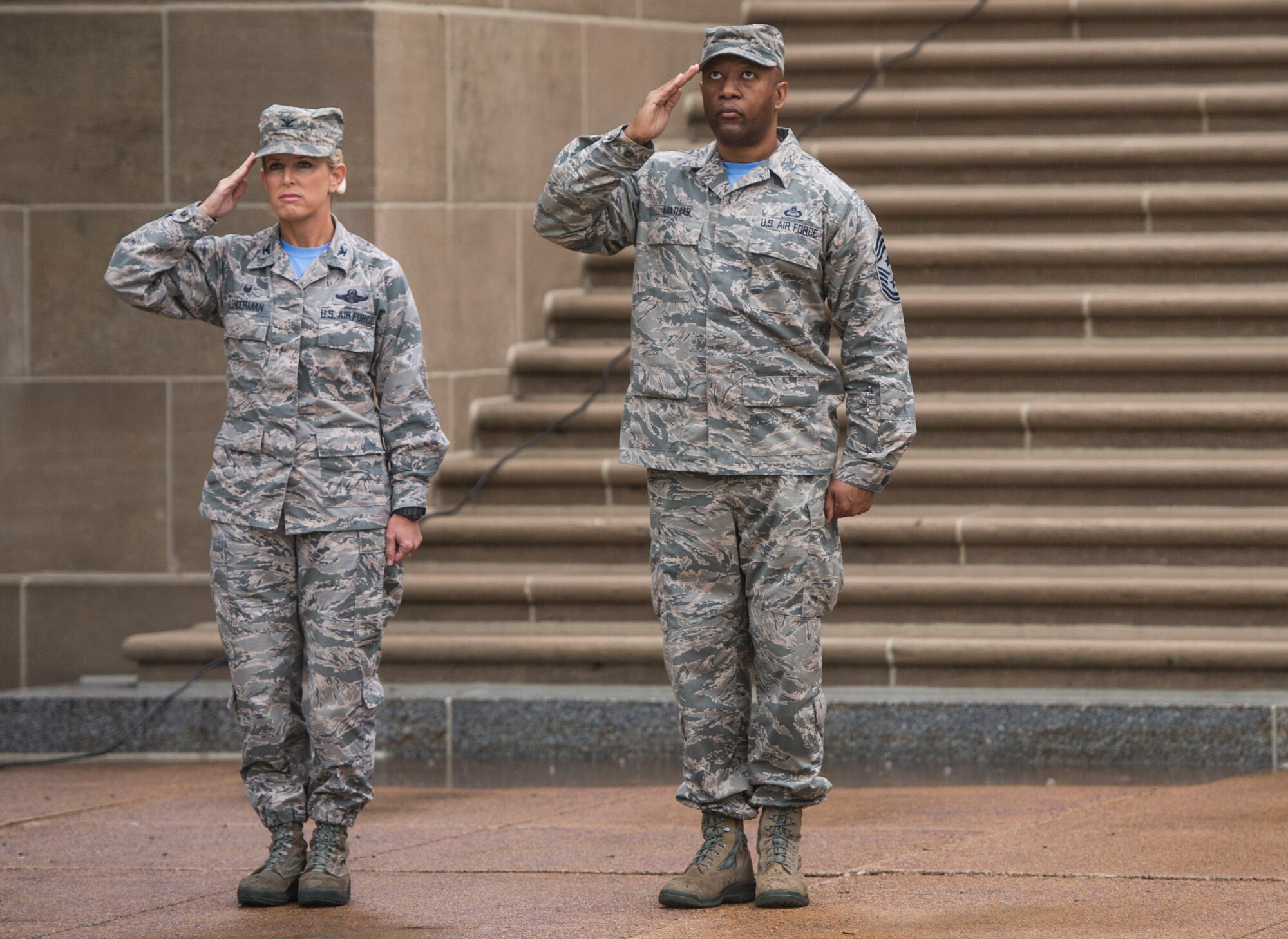 Col. Laura Lenderman, 375th Air Mobility Wing Commander, and Chief Master Sgt. Wesley Mathias, 375th Air Mobility Wing Command Chief, salute the American flag during Reveille, Scott Air Force Base, Ill., Sept. 9, 2016. (U.S. Air Force photo/Staff Sgt. Jodi Martinez)