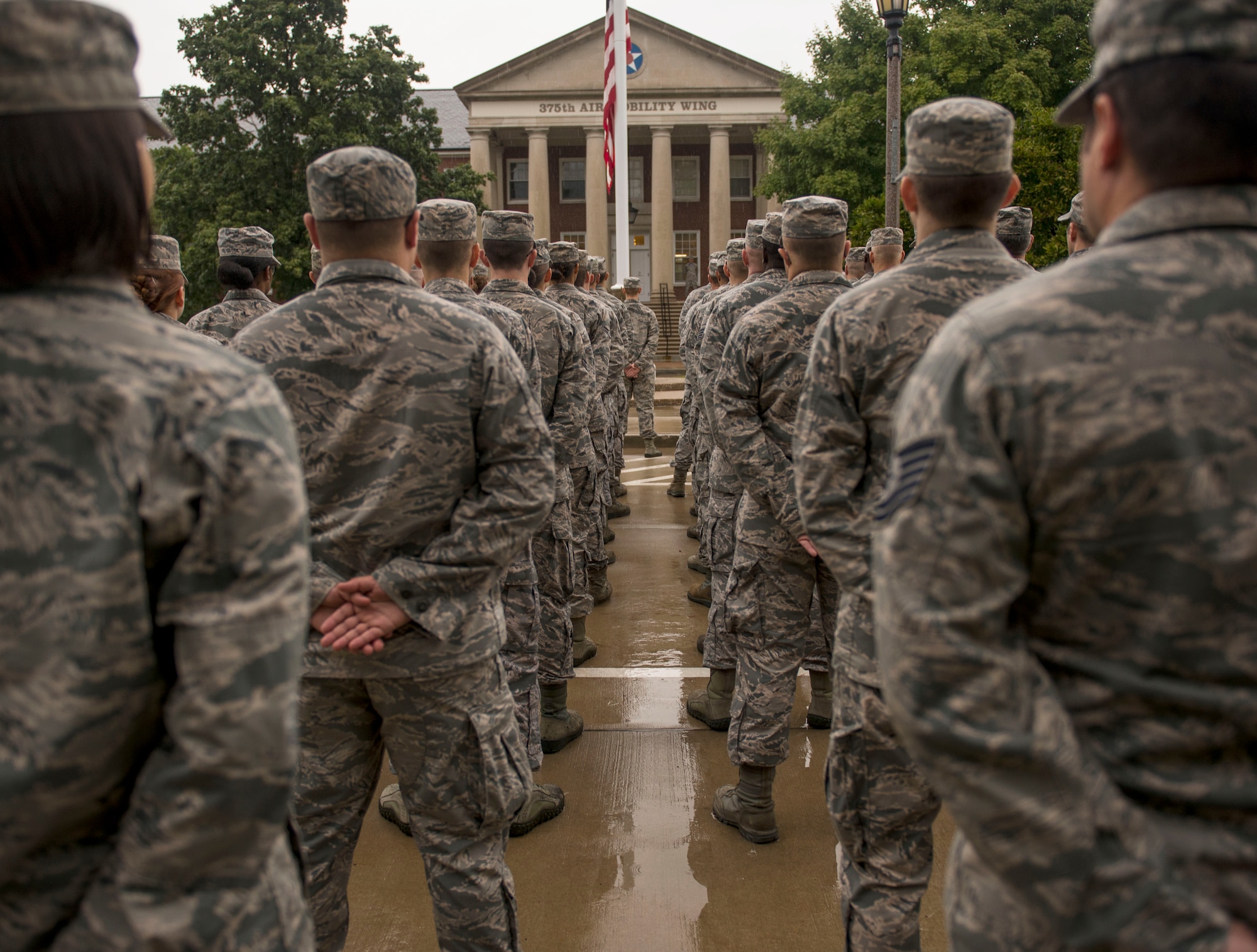 A formation stands at parade rest after the American flag was brought to half-mast during Reveille, Scott Air Force Base, Ill., Sept. 9, 2016.  (U.S. Air Force photo by Staff Sgt. Jodi Martinez)