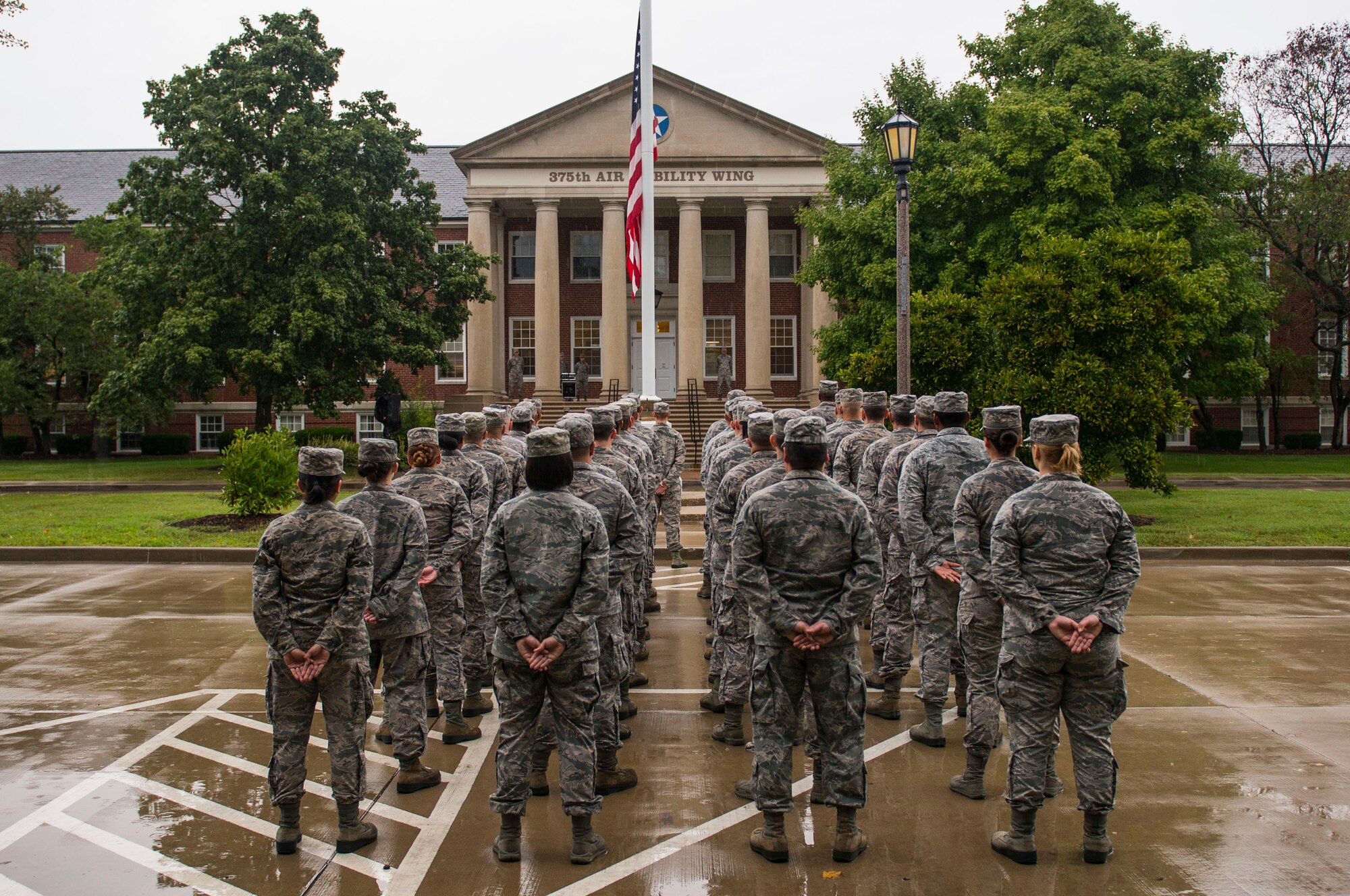 A formation stands at parade rest after the American flag was brought to half-mast during Reveille, Scott Air Force Base, Ill., Sept. 9, 2016.  (U.S. Air Force photo by Staff Sgt. Jodi Martinez)