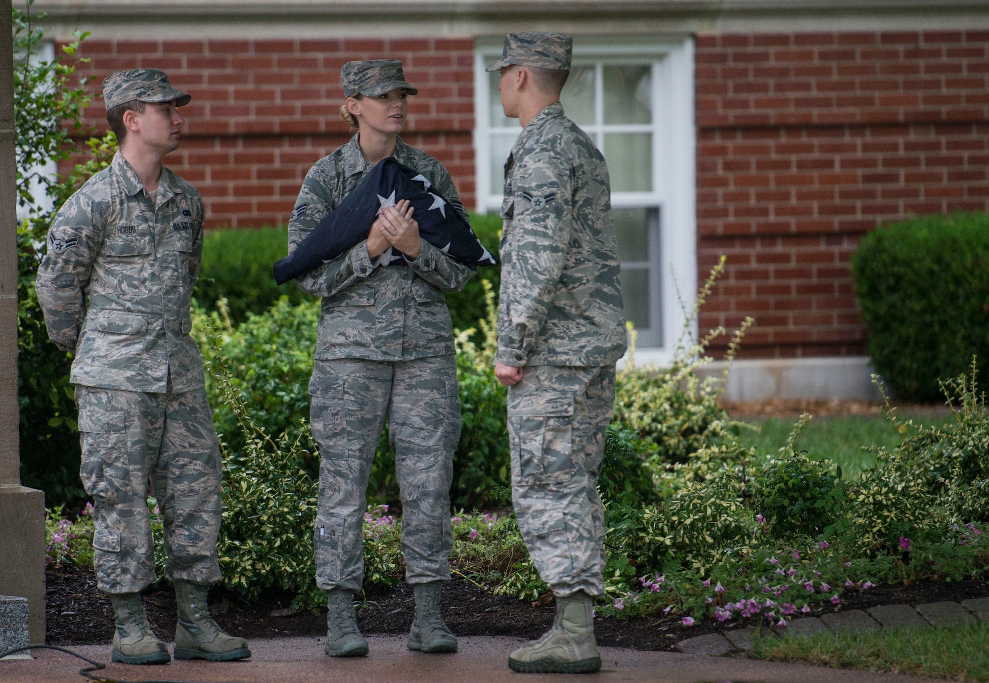 Airman 1st Class Brandon Hobbs, Senior Airman Rachel Ollie, and Airman 1st Class Adam Dann, all with the 375th Communications Squadron, standby before the start of Reveille, Scott Air Force Base, Ill., Sept. 9, 2016. (U.S. Air Force photo/Staff Sgt. Jodi Martinez)