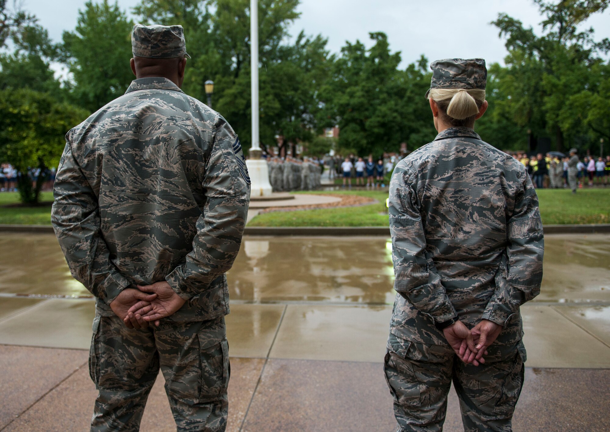 Chief Master Sgt. Wesley Mathias, 375th Air Mobility Wing Command Chief, and Col. Laura Lenderman, 375th Air Mobility Wing Commander, stand at parade rest in front of the crowd of people attending Reveille, Scott Air Force Base, Ill., Sept. 9, 2016. (U.S. Air Force photo/Staff Sgt. Jodi Martinez)