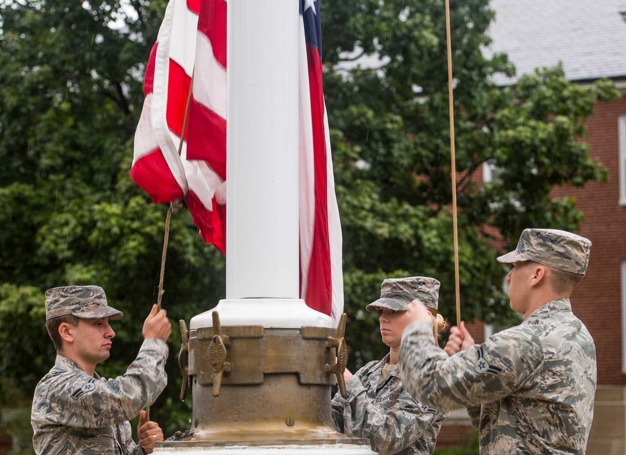 Airman 1st Class Brandon Hobbs, Senior Airman Rachel Ollie, and Airman 1st Class Adam Dann, all with the 375th Communications Squadron, raise the American flag in honor of Patriot Day, Scott Air Force Base, Ill., Sept. 9, 2016. (U.S. Air Force photo/Staff Sgt. Jodi Martinez)